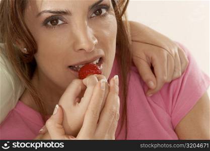Close-up of a daughter feeding her mother a strawberry