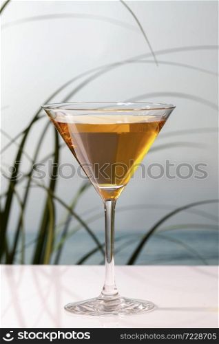 Close up of a delicious looking cocktail in a martini glass on a table on an out of focus background. Holiday and leisure concept.. a delicious looking cocktail in a martini glass on a table on an out of focus background. Holiday concept.