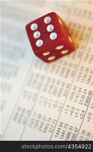 Close-up of a dice on a financial page
