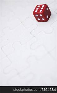 Close-up of a dice on a jigsaw puzzle