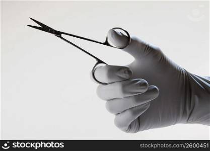Close-up of a doctor&acute;s hand holding a pair of scissor