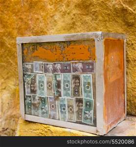 Close-up of a donation box with currency notes in Drepung Monastery, Lhasa, Tibet, China