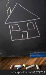 Close-up of a drawing of a house on a blackboard