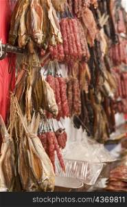Close-up of a dried fish and sausages at a market stall