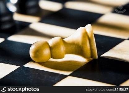 Close-up of a fallen pawn on a chessboard