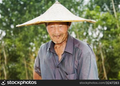 Close-up of a farmer wearing an Asian style conical hat, Zhigou, Shandong Province, China