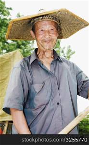Close-up of a farmer wearing an Asian style conical hat, Zhigou, Shandong Province, China