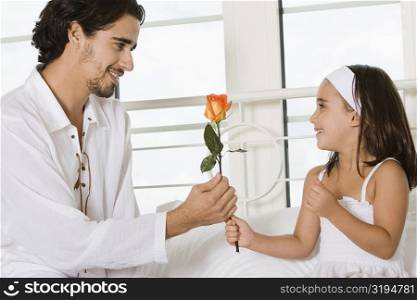 Close-up of a father giving his daughter a rose
