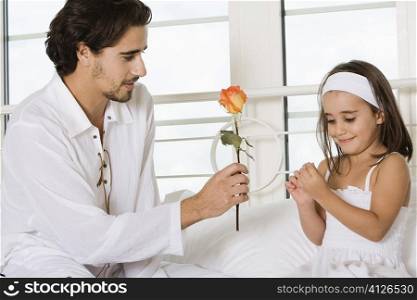 Close-up of a father giving his daughter a rose