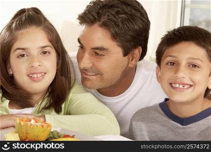 Close-up of a father with his son and his daughter smiling