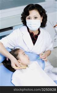 Close-up of a female dentist examining a girl&acute;s teeth