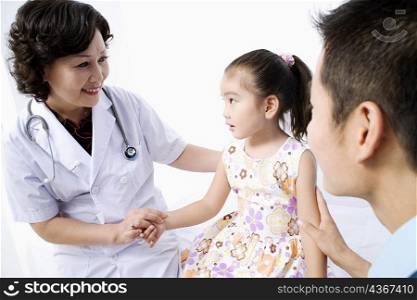 Close-up of a female doctor examining a girl and smiling