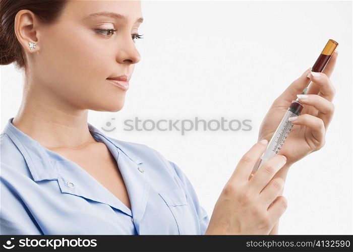 Close-up of a female doctor filling a syringe from a vial