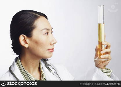 Close-up of a female doctor holding a graduated cylinder