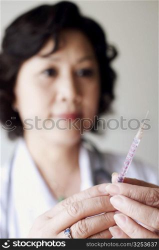Close-up of a female doctor holding a syringe