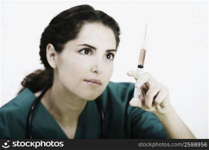 Close-up of a female doctor in scrubs with a syringe