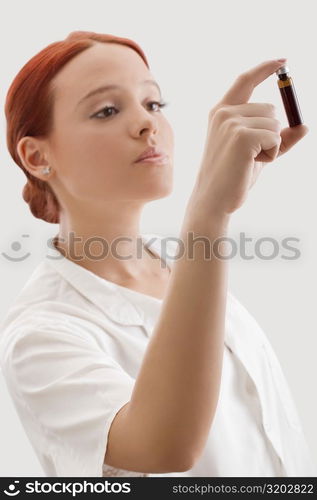 Close-up of a female doctor looking at a vial