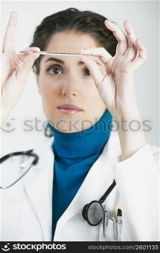 Close-up of a female doctor reading a thermometer