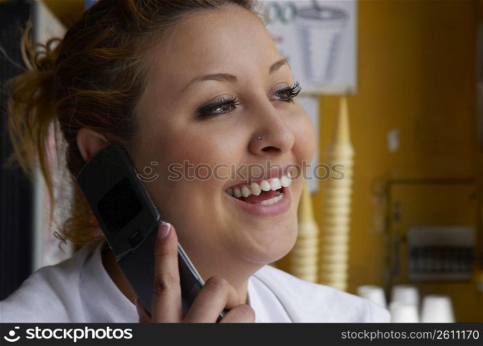 Close-up of a female ice-cream shop owner talking on a mobile phone