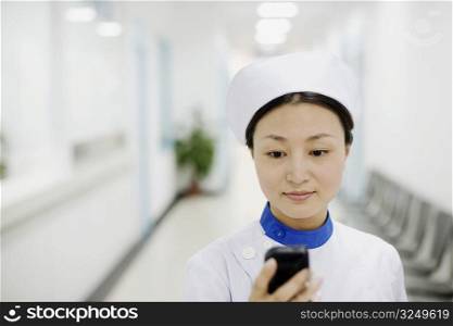 Close-up of a female nurse operating a mobile phone