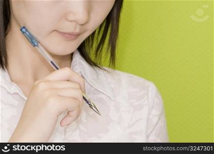 Close-up of a female office worker holding a pen