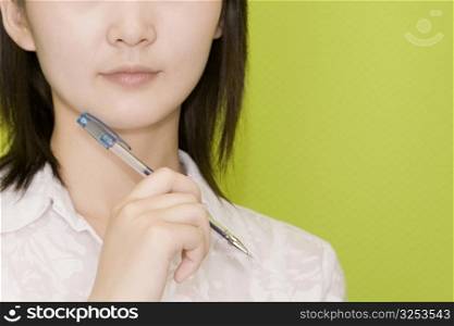 Close-up of a female office worker holding a pen
