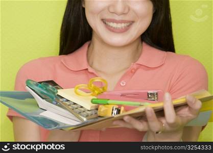Close-up of a female office worker holding stationery objects