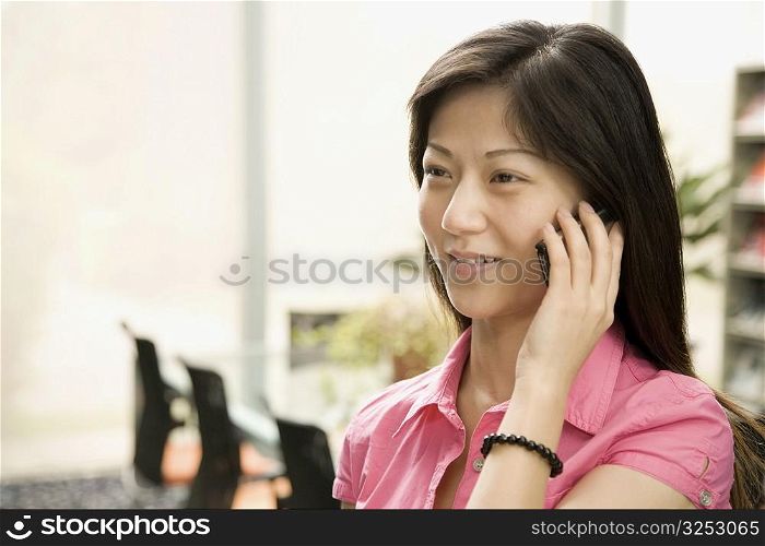 Close-up of a female office worker talking on a mobile phone and smiling