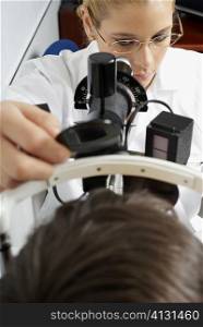Close-up of a female optometrist examining eyes of a patient