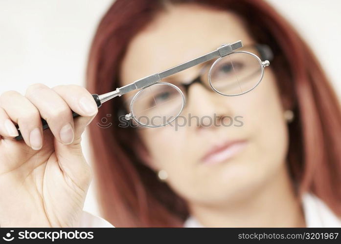 Close-up of a female optometrist holding an eye test equipment