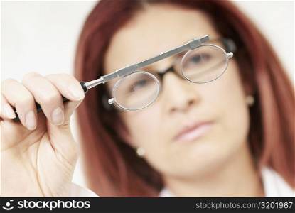 Close-up of a female optometrist holding an eye test equipment