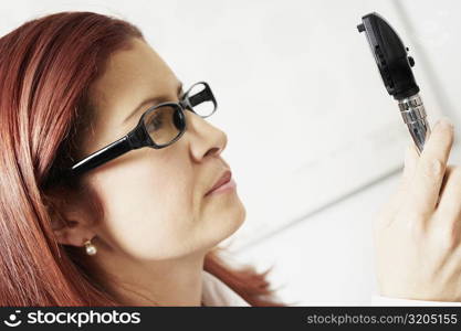 Close-up of a female optometrist holding an eye test equipment