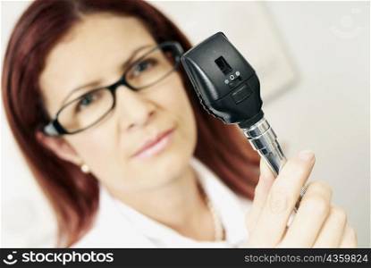 Close-up of a female optometrist holding an eye test equipment