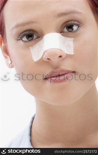 Close-up of a female patient with an adhesive bandage on her nose