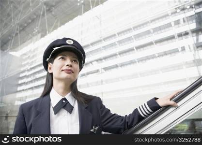 Close-up of a female pilot standing on an escalator