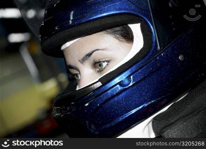 Close-up of a female race car driver wearing a crash helmet