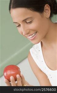 Close-up of a female teacher holding an apple and smiling