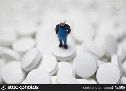 Close-up of a figurine on the heap of pills