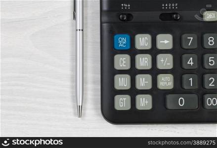 Close up of a financial calculator and pen on desktop.