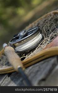 Close-up of a fishing rod with a fishing reel and a net