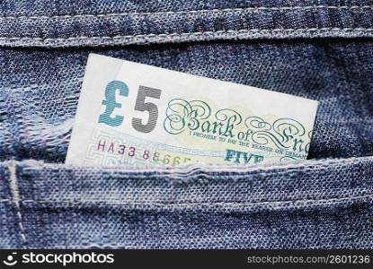 Close-up of a five pound note in a back pocket