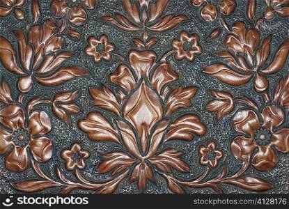 Close-up of a floral pattern carved on a wooden surface