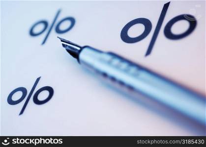 Close-up of a fountain pen and percentage signs