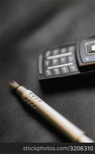 Close-up of a fountain pen near a mobile phone