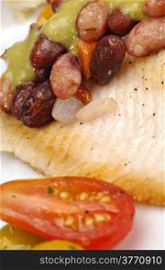 Close up of a fresh cod fillet with a black bean salsa.
