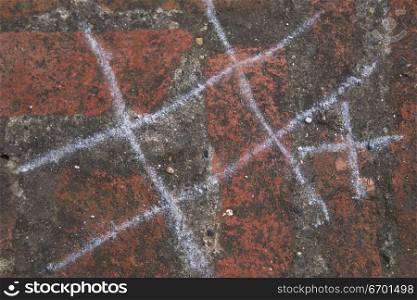 Close-up of a game of tic tac toe made with chalk on a wall