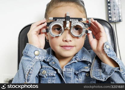 Close-up of a girl adjusting a phoropter in a doctor&acute;s office