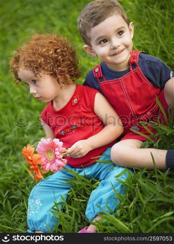 Close-up of a girl and her brother sitting together