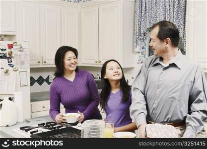 Close-up of a girl and her parents in the kitchen