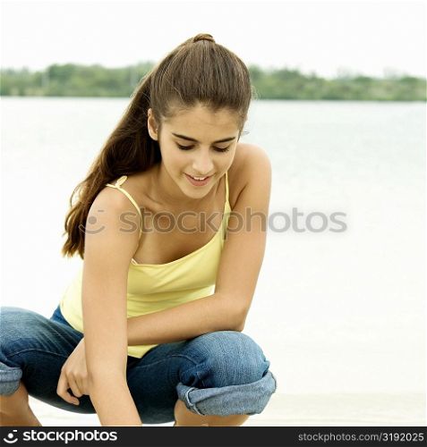 Close-up of a girl crouching on the beach